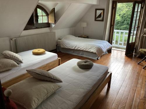 a bedroom with two beds and a window at Retraite Paisible au Cœur de la Forêt de Rambouillet avec Étang Privé et Charme Authentique - FR-1-527-8 in Clairefontaine