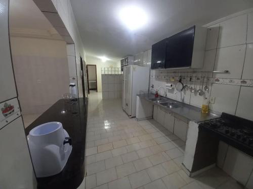 eine große Küche mit weißen Geräten und Fliesenboden in der Unterkunft Casa com piscina in Palmas