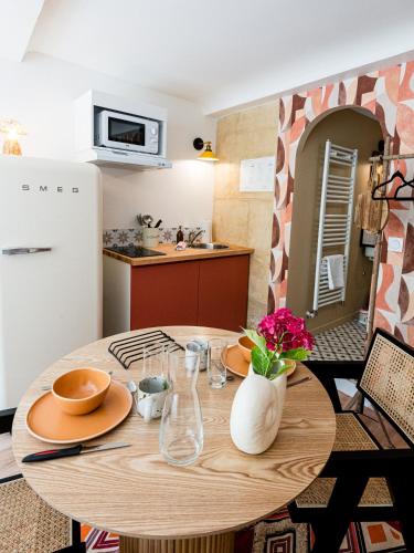 a table with plates and glasses on it in a kitchen at Villa Robs - Appartements tout confort, TV connectée, Haut débit, Localisation idéale - Courts séjours & Affaires in Caen