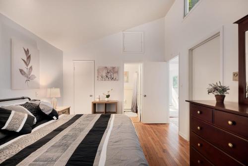 a bedroom with white walls and a large bed at Cabin w Hot Tub, WiFi, Deck, Grill & Dog-Friendly! in Berkeley Springs