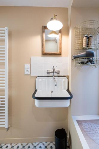 a bathroom with a sink and a mirror at Villa Robs - Appartements tout confort, TV connectée, Haut débit, Localisation idéale - Courts séjours & Affaires in Caen
