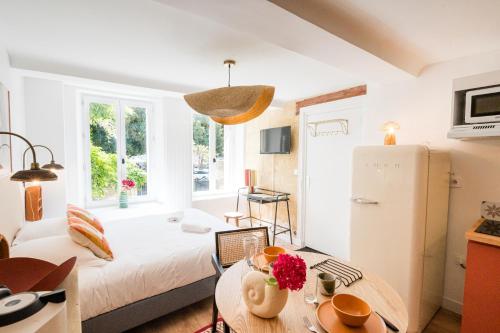 a small living room with a bed and a table at Villa Robs - Appartements tout confort, TV connectée, Haut débit, Localisation idéale - Courts séjours & Affaires in Caen