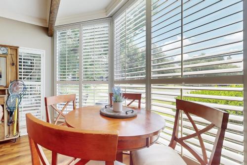 a dining room with a table and chairs and windows at Lavish World of Tennis in Lakeway
