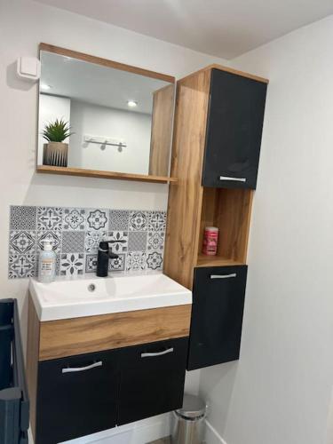 une salle de bain avec un lavabo et un miroir dans l'établissement Maison Centre Brem avec vue sur la côte, à Brem-sur-Mer