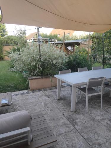 a white table and chairs under an umbrella at Les hunaudieres 4 chambres - 4 lits doubles in Teloché
