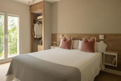 a bedroom with a large bed with pink pillows at Amalurra Ecohotel & Retreat Center in Artzentales