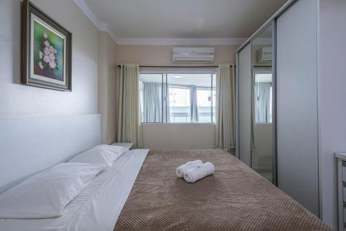 a bedroom with a bed with two towels on it at ITNC013 - Avenida Atlântica | Amplo apê com 3Q+3WC in Balneário Camboriú