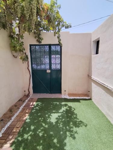 a door to a house with a green lawn at Appartement T2 60m2 Djerba Houmet Essouk in Houmt Souk