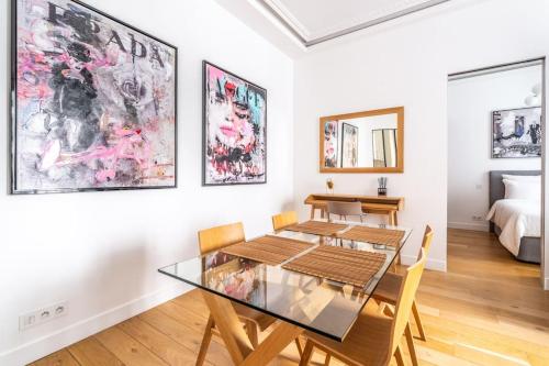 - une salle à manger avec une table, des chaises et un lit dans l'établissement Luxury Appartement Champs Elysees, à Paris