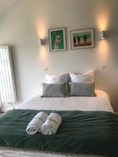 une chambre avec un lit avec deux serviettes dessus dans l'établissement HORIZON VUE MER parking gratuit, à Deauville