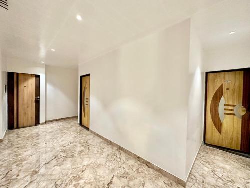a hallway with white walls and wooden doors at TAKHT- Executive Suites and Rooms in Chinchiwad