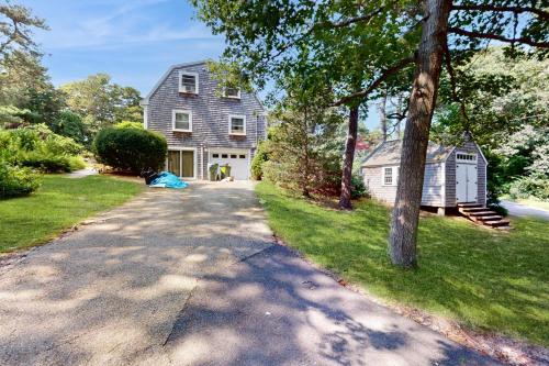 a driveway leading to a large gray house at Bumps River Bungalow in Centerville