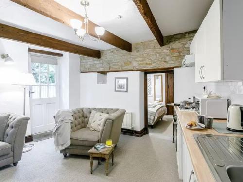a living room with a couch and a kitchen at Barlow Country Club - Mill Farm Cottages in Dronfield
