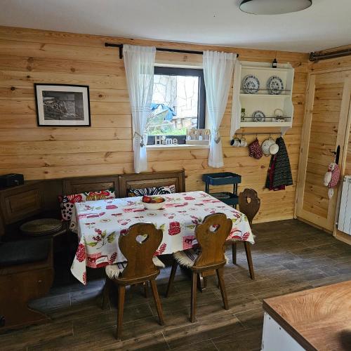 a dining room with a table and chairs in a cabin at Black Lake Chalet in Žabljak