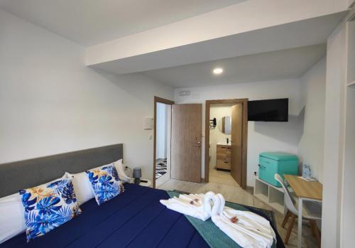 a bedroom with a blue bed with towels on it at Pension Casa Pedro in Fisterra