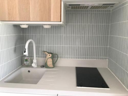 - un comptoir de cuisine avec un évier et un robinet dans l'établissement HORIZON VUE MER parking gratuit, à Deauville
