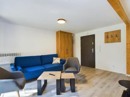 a living room with a blue couch and chairs at Apartamenty Familly Dąbrówka - przy parku, prywatny parking, sauna, ogód - by SpaceApart in Jelenia Góra