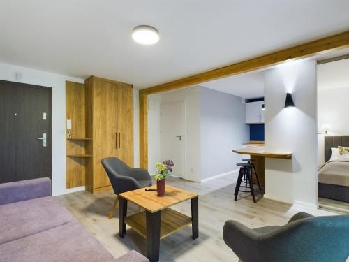 a living room with a couch and a table at Apartamenty Familly Dąbrówka - przy parku, prywatny parking, sauna, ogód - by SpaceApart in Jelenia Góra