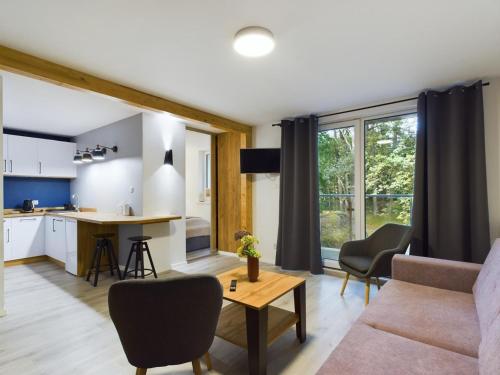 a living room with a couch and a table at Apartamenty Familly Dąbrówka - przy parku, prywatny parking, sauna, ogód - by SpaceApart in Jelenia Góra
