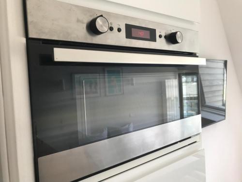 d'un four micro-ondes avec un réveil. dans l'établissement HORIZON VUE MER parking gratuit, à Deauville