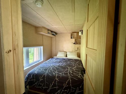 a bedroom with a bed in a small room at Cabin Zoobox 63 in Eastman