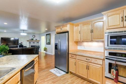 a kitchen with wooden cabinets and stainless steel appliances at Anchorage Home about 8 Mi to Downtown! in Anchorage