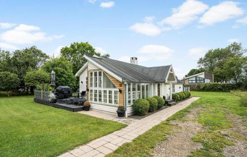 a white shed with a black roof in a yard at Holiday Home Bjørnsknudevej Juelsminde Iii in Juelsminde