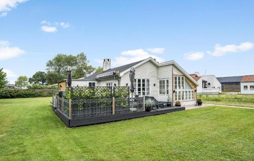 a white house with a fence in the yard at Holiday Home Bjørnsknudevej Juelsminde Iii in Juelsminde