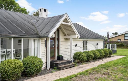 a white house with a black roof at Holiday Home Bjørnsknudevej Juelsminde Iii in Juelsminde