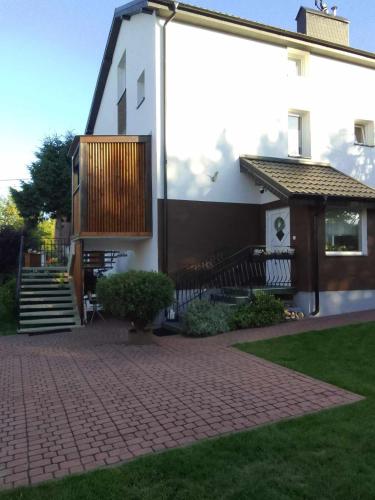 a house with a brick driveway in front of it at Apartament i pokoje na Sosnowej in Ostrowo