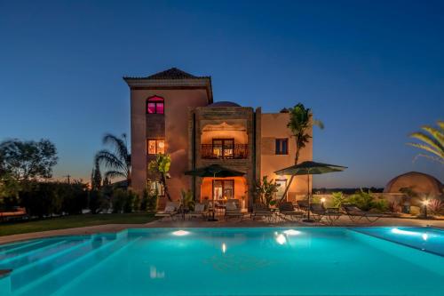 a large house with a swimming pool in front of it at Al Karob Yoga Boutique Villa in Guia
