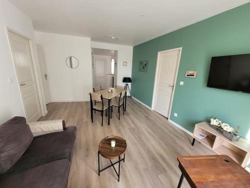una sala de estar con un sofá y una mesa en Logement centre le bugue, en Le Bugue