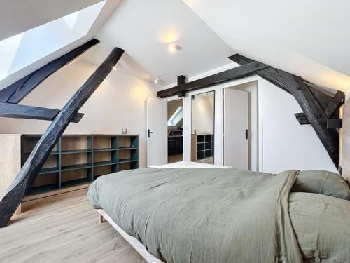 une chambre avec un grand lit dans un grenier dans l'établissement le vert, à Troyes