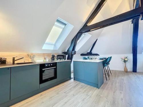 une cuisine avec des armoires bleues, un évier et une table dans l'établissement le vert, à Troyes