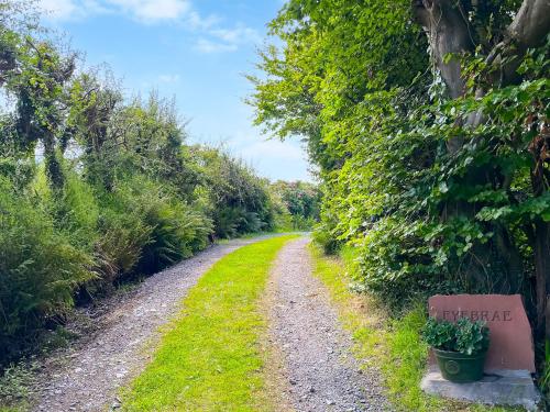 a gravel road with a bench on the side at Fyebrae in Stranraer