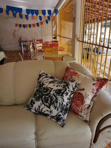 a couch with two pillows on it in a living room at Sos Hostel in Camaçari