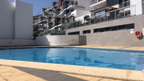 a large blue swimming pool in front of a building at Magic Paradisus guest in Caniço