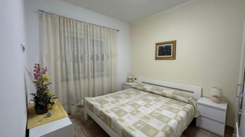 a small bedroom with a bed and a window at Apartmani Nada in Pula