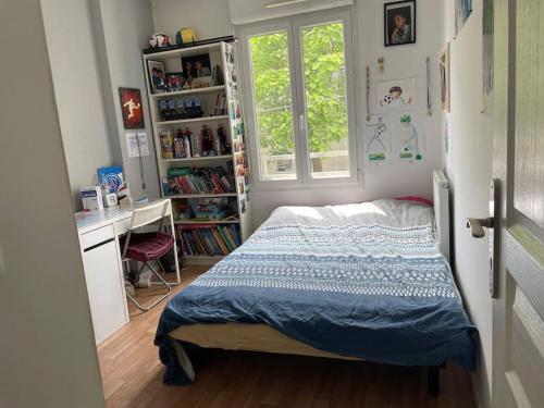 une chambre avec un lit, un bureau et une fenêtre dans l'établissement JO Sweet Appartement au porte de PARIS, à Ivry-sur-Seine