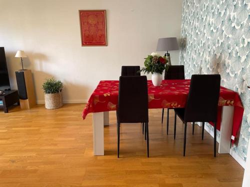 une table à manger avec des chaises et un tissu de table rouge dans l'établissement JO Sweet Appartement au porte de PARIS, à Ivry-sur-Seine