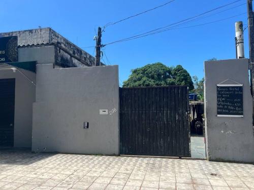 a gate to a building with a sign on it at Kitnet para Temporada na Praia Simples in Bertioga