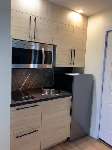 a kitchen with a sink and a refrigerator at Shores Inn & Hotel in Shediac