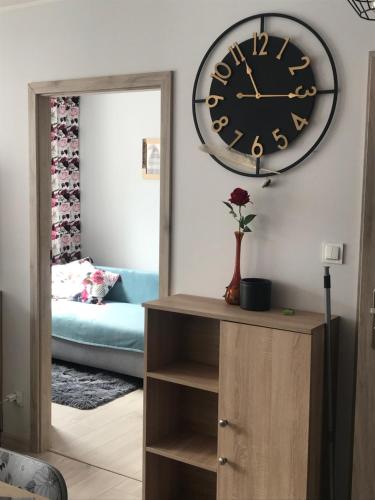 a clock on the wall above a dresser with a mirror at Kosmos nad morzem in Dziwnówek