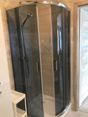 a shower with a glass door in a bathroom at Kosmos nad morzem in Dziwnówek