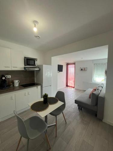 une cuisine et un salon avec une table et des chaises dans l'établissement L'ethnique cottage 30m2 2 personnes avec extérieur, à Villeneuve d'Ascq