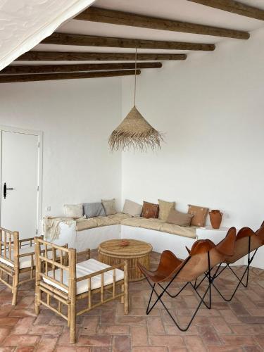 a living room with a couch and a table and chairs at Casa do Pátio - Barragem do Alqueva in Granja