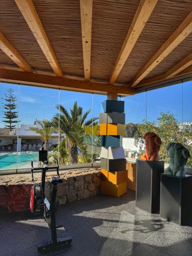 a room with a gym with a view of a pool at Axel Beach Mykonos - Adults Only in Mýkonos City