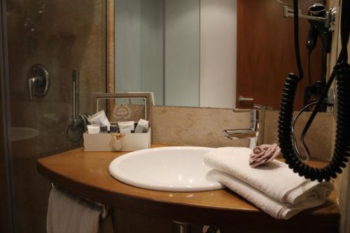a bathroom sink with towels on a counter at Hotel Marisqueria Cal Tet in L'Estartit