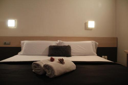 a bedroom with a bed with towels on it at Hotel Marisqueria Cal Tet in L'Estartit