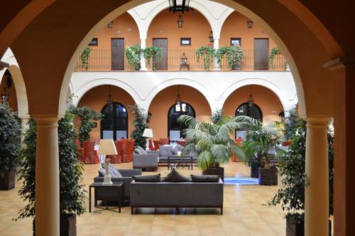 a lobby of a hotel with couches and plants at Hacienda Montija Hotel in Huelva